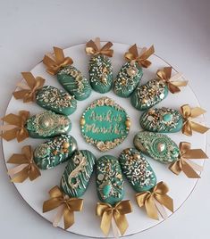 a white plate topped with green and gold decorated cookies