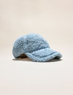 a light blue hat is laying on the floor and it's made out of fleece