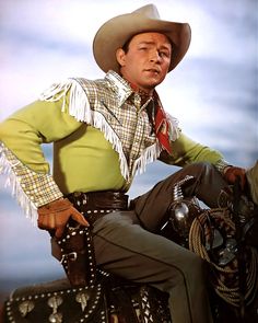 a man sitting on top of a horse wearing a cowboy hat