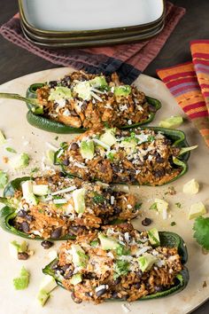 several stuffed peppers on a plate with cheese and other toppings