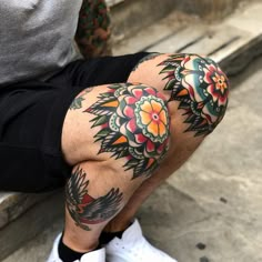 a man with tattoos on his leg and knee is sitting in front of some steps