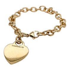 This is part of Chairish’s Fine Jewelry assortment.  A very fine Tiffany Co. bracelet.  In 18k gold.  With slightly oval links and a heart-shaped pendant charm.  The charm is not engraved.  Simply wonderful, classic Tiffany design!  Date: 20th Century  Overall Condition: It is in overall good, as-pictured, used estate condition with some very fine light surface scratches and other signs of expected light wear consistent with age.  Fineness: Marked 750 for 18k gold fineness.  Marks: Tiffany Co. / Elegant Gold-tone Charm Bracelet With Logo, Elegant Heart Bracelet With Charms, Classic Engraved Charm Bracelet For Formal Occasions, Elegant Engraved Oval Link Gold Bracelet, Elegant Charm Bracelet With Logo Charm As Gift, Elegant Engraved Gold Oval Link Bracelet, Classic Heart Charm Bracelet, Luxury Yellow Gold Charm Bracelet With Logo, Classic Gold Bracelet With Logo Charm