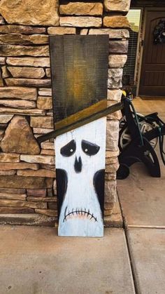 a painting of a skeleton wearing a hat on the side of a stone wall next to a bike