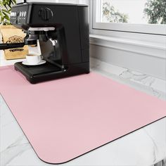 a pink mat with a coffee machine on it