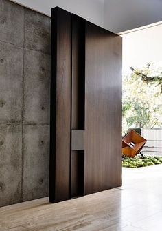 an open door leading into a room with concrete walls and flooring on either side