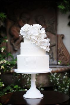 a white wedding cake with flowers on top