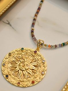 The Ra Pendant is as powerful and mighty as the God himself. This medallion is studded with the 9 precious and semi-precious gems (also known as Navratna). Stone: Emerald, Ruby, Sapphire, Gomed, Cat's Eye, Zircon, Citrine, Red Coral, Pearl Metal: Brass Alloy Plating: Micron (18k gold), Nickel-free & Lead-free Gold Plated Amulet Pendant Jewelry, Gold Plated Gemstone Amulet Jewelry, Gold Amulet Pendant Crystal Necklaces, Gold-tone Amulet Necklace With Round Pendant, Gold-tone Medallion Amulet Necklace, Semi Precious Gems, Casual Jewelry, Precious Gems, Red Coral