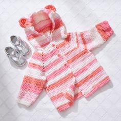 a crocheted sweater and pair of baby shoes