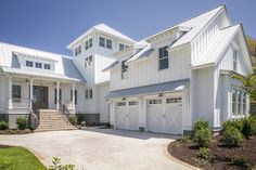 a large white house with two garages on each side