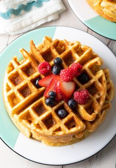 two waffles with strawberries and blueberries sitting on top of each other