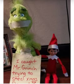 an elf holding a sign that says i caught mr grinch trying to steal xmas