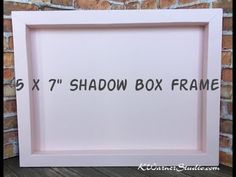 the shadow box frame is white and has black lettering on it that says x7's shadow box frame