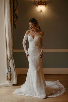 a woman in a white wedding dress posing for the camera with her hands on her hips