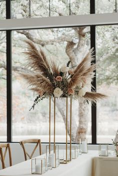 tall gold vases filled with flowers and feathers