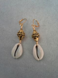 Beautiful cowrie shells beads and design, lightweight, earrings are a totally unique design and are 1 1/2 inches long with gold leverback earwires. . Please come back and visit to check for new unique designs. For more styles visit my Etsy shop: www.etsy.com/shop/SoftlySisterDesigns White Brass Earrings For Beach, White Brass Earrings For The Beach, Unique Gold Earrings For Beach, Beach Beaded Metal Earrings, Metal Beaded Earrings For Beach, Beach Brass Dangle Earrings, Unique Gold Jewelry For Vacation, Unique Nickel-free Earrings For Beach, Bohemian Shell Earrings For Jewelry Making