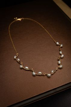 A handmade necklace with small freshwater pearls woven onto hammered gold-filled connector bars. Specifications: Length: 18 inches Materials: 18k Gold, Sterling Silver, Freshwater Pearls 90-97% Clear, High Luster/Nacre All orders come with a handwritten note, a sturdy cardboard drawer box, and a velvet pouch. Note: Each piece is hand-selected and hand-made to order. All of our natural materials vary in size and detailing, so each piece is uniquely your own. Made to order: ships within 2 to 4 wee Pearl Wire Necklace, Pearl With Gold Necklace, Edwardian Jewelry Necklaces, Jwellary Unique, Unique Pearl Necklace, Pretty Gold Necklaces, Small Gold Necklace, Vine Necklace, Pearl Gold Necklace