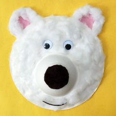 a paper plate with a polar bear face on it's side against a yellow background