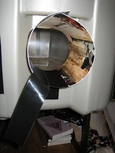 a white urinal sitting on top of a wooden floor next to a pile of books