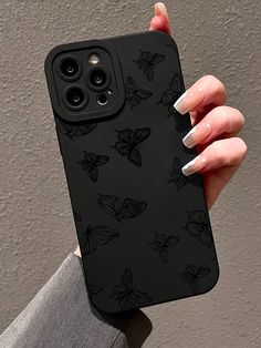 a woman's hand holding up a black phone case with butterflies printed on it