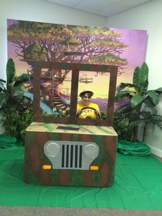 a jeep made out of cardboard sitting in front of a painting