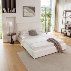 a white bed sitting on top of a wooden floor