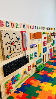 a child's playroom with lots of colorful toys on the wall and floor