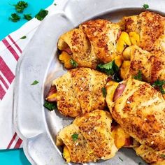 a pan filled with chicken and vegetables on top of a blue table cloth next to a red and white towel