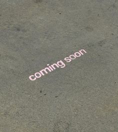 the word coming soon written in pink on concrete