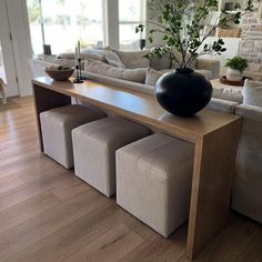 a living room filled with furniture and a large vase on top of a wooden table