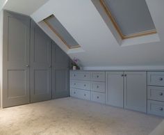 an attic bedroom storage room with drawers and cupboards