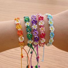 a person's arm with four bracelets on top of it and one is made out of multicolored beads