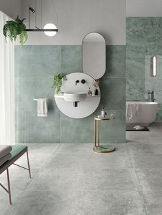 a modern bathroom with green marble walls and flooring, including a round mirror on the wall