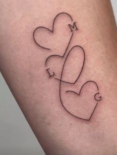 a couple of hearts that are on the side of a woman's leg with an arrow