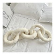 two white rings are laying on the bed next to an open laptop and pillow case