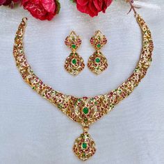 A light weight elegant necklace set in gold plated 22k silver set with precious freshwater pearls and synthetic rubies and emeralds. The earrings come with a bombay screw closure. Weight 31 GMs Gold Emerald Necklace For Formal Festivals, Formal Temple Jewelry Style Gold Emerald Necklace, Formal Gold Emerald Temple Jewelry Necklace, Formal Gold Emerald Necklace For Festivals, Traditional Yellow Gold Emerald Necklace For Formal Occasions, Traditional Yellow Gold Emerald Necklace For Formal Events, Elegant 22k Gold Emerald Necklace For Celebration, Traditional Gold Emerald Necklace With Jewels, 22k Gold Temple Jewelry Emerald Necklace For Celebration