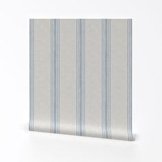 a white and blue striped wallpaper with vertical stripes on the bottom half of it