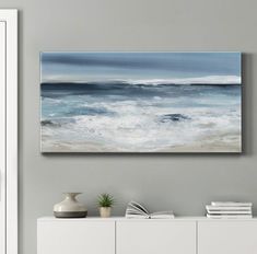 an ocean scene with waves crashing on the shore and blue sky above it, framed in white