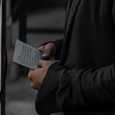 a person holding a piece of paper with writing on it in their left hand while standing next to a door