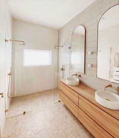 a bathroom with two sinks and a large mirror on the wall next to each other