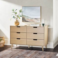 a wooden dresser with drawers and a painting on the wall