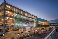 a large building with lights on it next to a highway