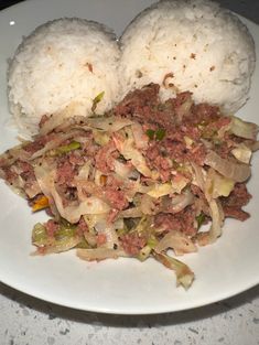 a white plate topped with rice and meat