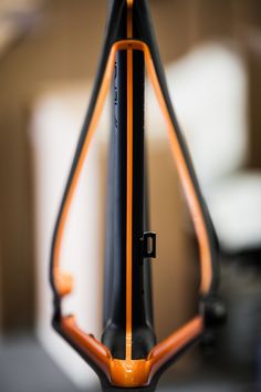 an orange and black bike handlebars are seen in this close up shot,