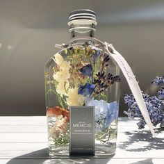 a bottle filled with flowers sitting on top of a table