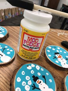 decorated cookies with frosting and snowmen on them, sitting on a table next to a hammer