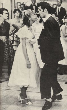 black and white photograph of man and woman dancing in front of people on the dance floor