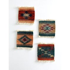 three small rugs are arranged on a white surface