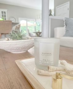 a white candle sitting on top of a wooden tray