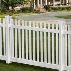 a white picket fence in front of a large house