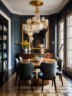 a dining room table with blue chairs and a chandelier